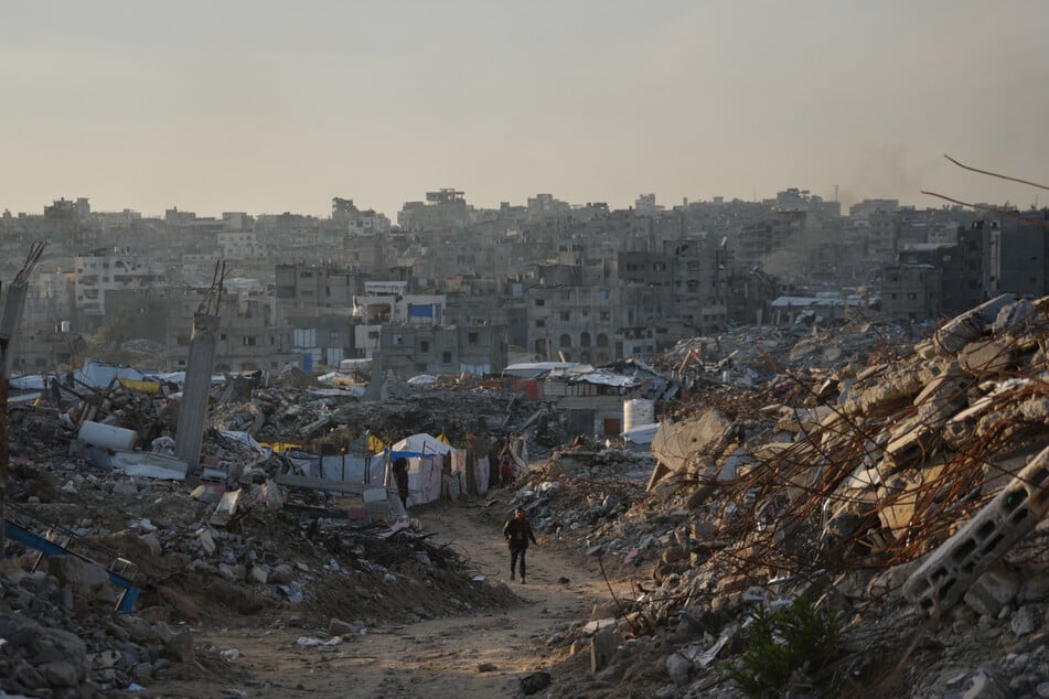 Ein Mann geht eine Straße in Gaza entlang, die bei israelischen Luft- und Bodenoperationen zerstört wurde.