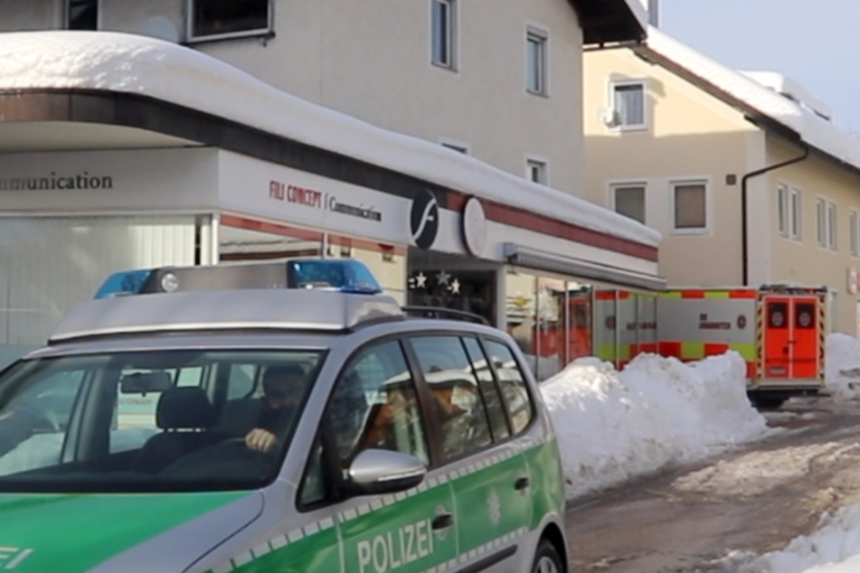 Einsatzfahrzeuge stehen an der Unfallstelle. Eine Frau wurde dort durch eine Dachlawine vollends begraben.