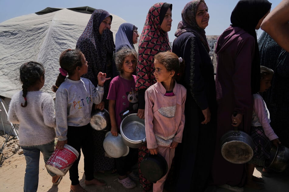 Vertriebene Palästinenser stellen sich in einem Zeltlager in Gaza-Stadt auf, um gespendete Mahlzeiten aus einer Gemeinschaftsküche zu erhalten.