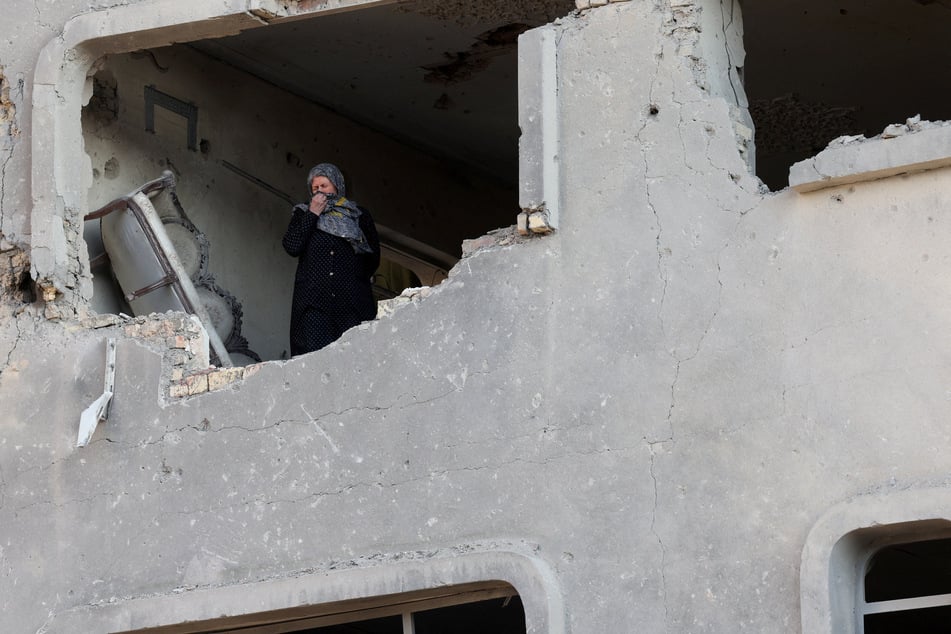 A woman stands inside a destroyed building in Tehran amid the US-Israeli war on Iran on March 21, 2026.