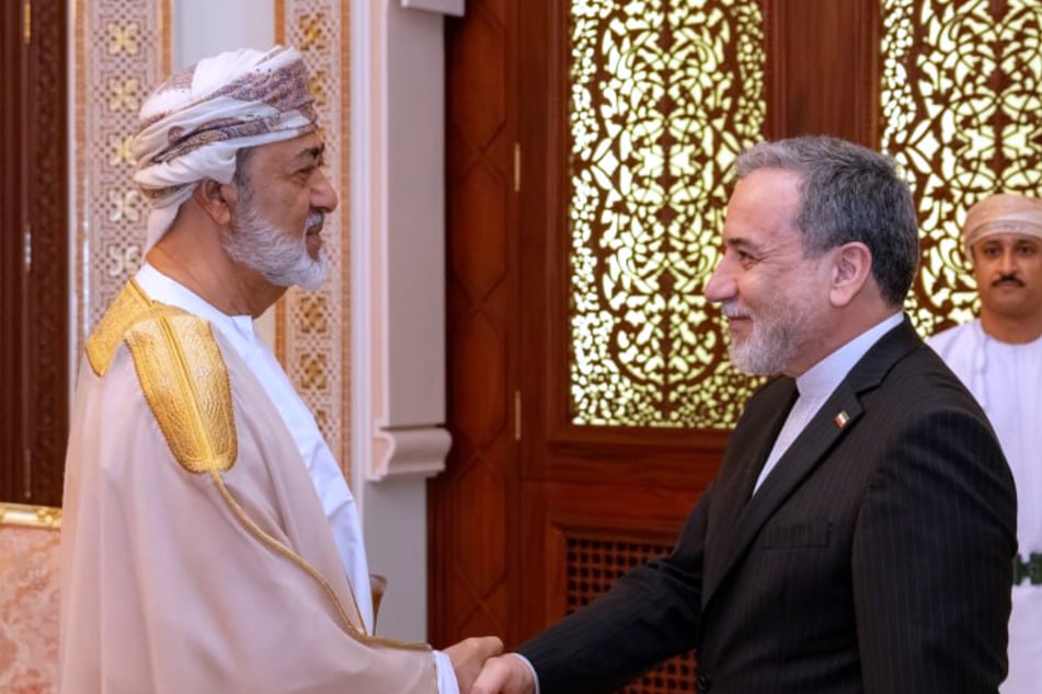 Auf diesem vom iranischen Außenministerium veröffentlichten Foto gibt der iranische Außenminister Abbas Araghtschi (63, r.) dem omanischen Sultan Haitham bin Tariq während ihres Treffens die Hand.
