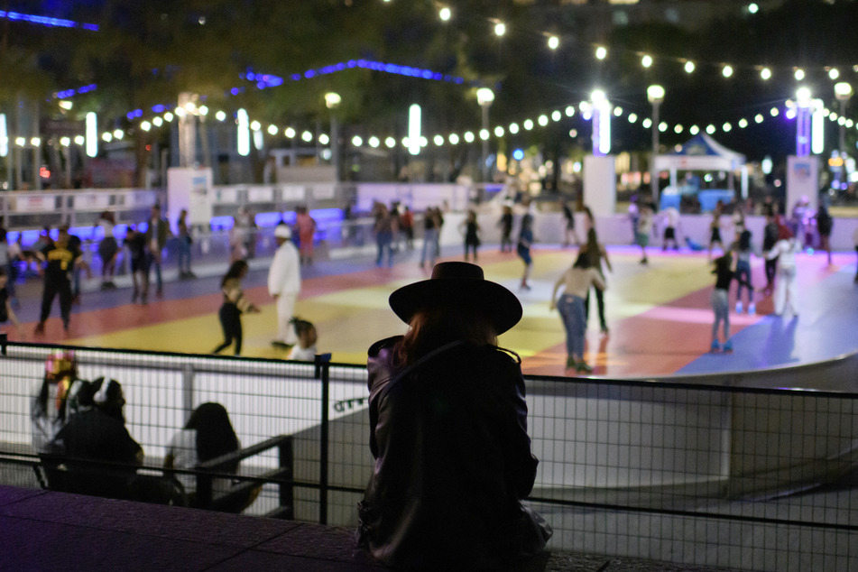 A woman watches roller skaters during a listening party for Beyonce's new album Cowboy Carter at Discovery Green’s outdoor roller skating rink in Houston, Texas on Friday.