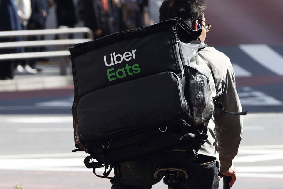 Ein Mitarbeiter des Essenslieferdienstes Uber Eats radelt mit einer Lieferung durch Tokio. Der Lieferservice plant in einigen Wochen den Einstieg in den deutschen Markt, beginnend in Berlin.