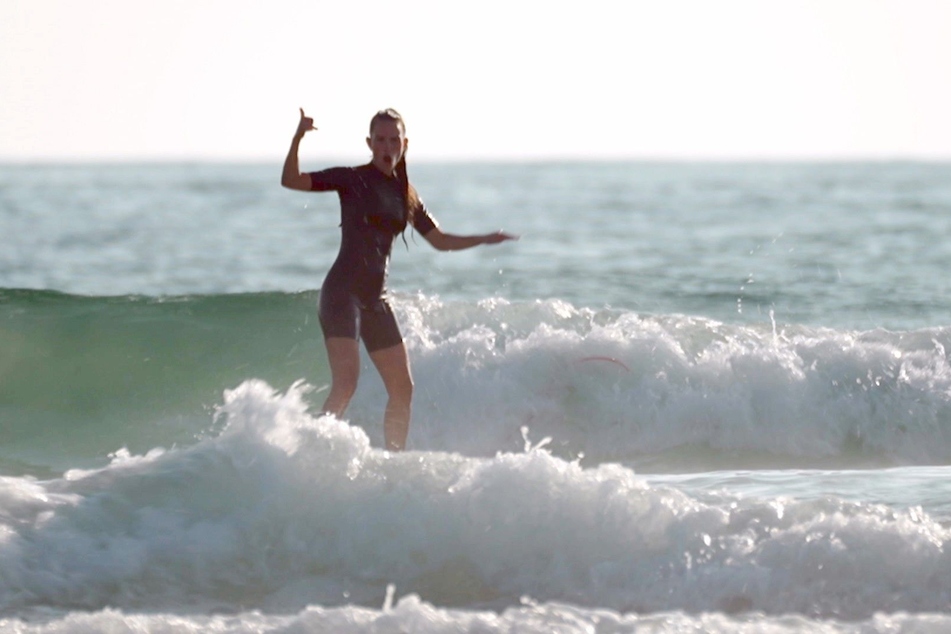 Lisa (32) beweist ihr Stehvermögen auf dem Surfboard.
