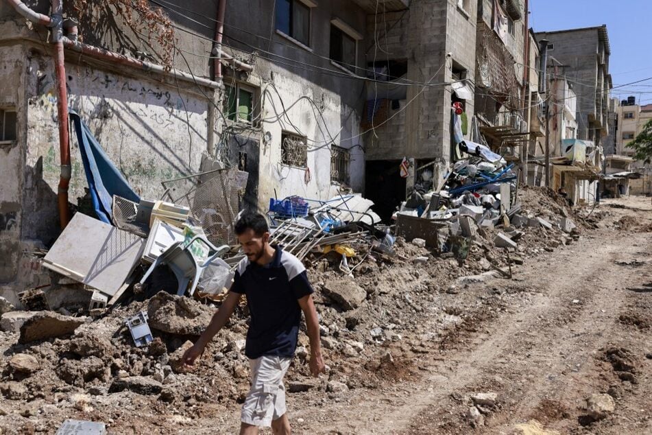 A man walks past debris on a damaged road following an Israeli army raid in Tulkarem, in the occupied West Bank.