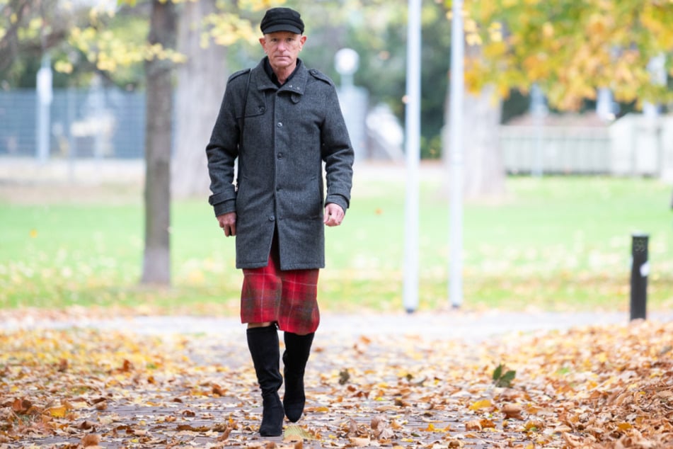 Mark Bryan, Influencer auf Instagram, geht unter einem Baum entlang. Er trägt gerne High Heels und zieht damit jede Menge Blicke auf sich.
