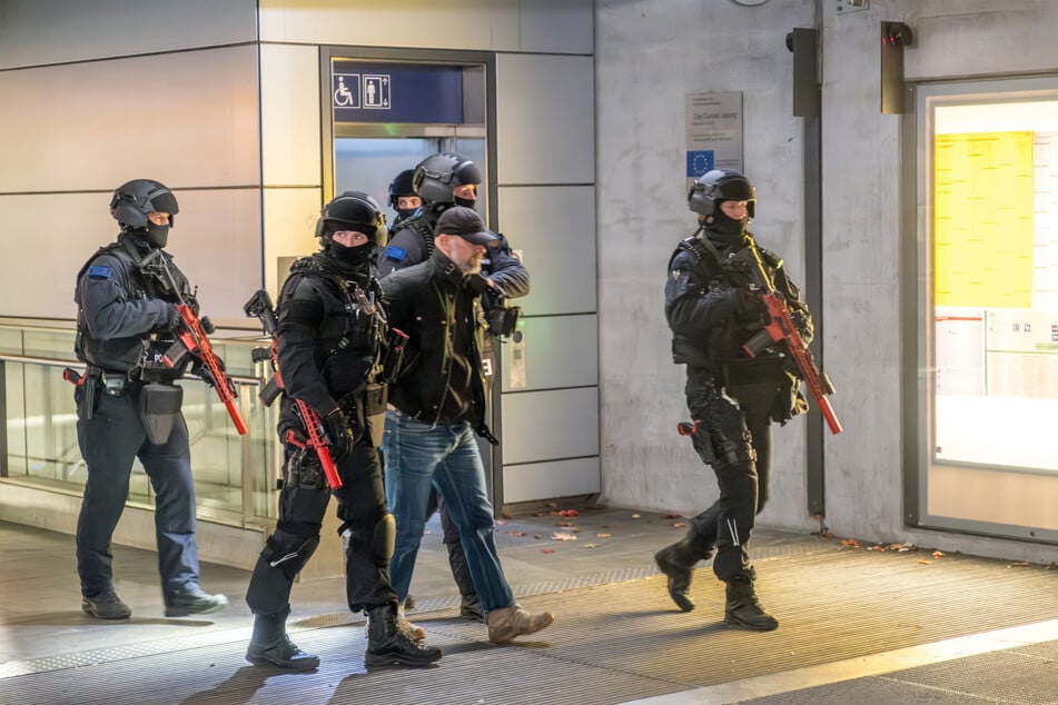 Schwerbewaffnete Polizisten führen den "Angreifer" (einen Schauspieler) ab.