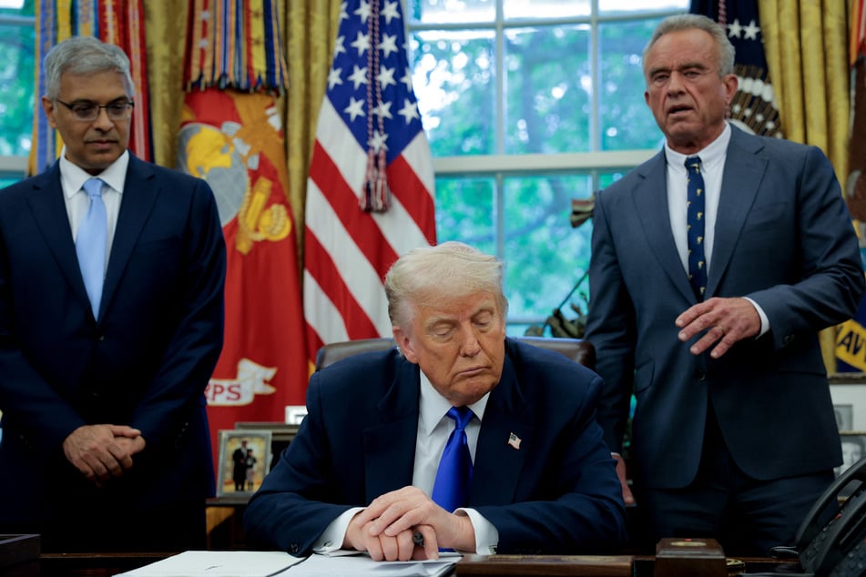 Health and Human Services Secretary Robert F. Kennedy Jr. (r.) speaks in the Oval Office at the White House, accompanied by President Donald Trump (c.) and National Institutes of Health Director Jayanta Bhattacharya (l.).