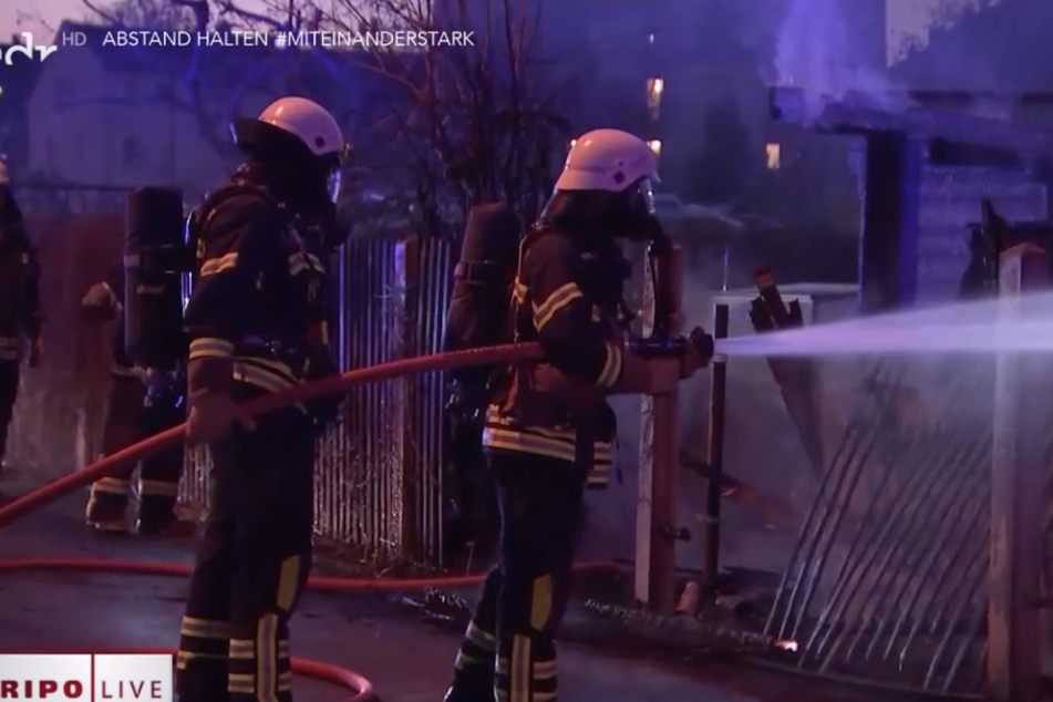 Feuerwehrleute versuchen am 6. April 2020, die brennende Laube von Hans-Dieter Speike zu löschen.