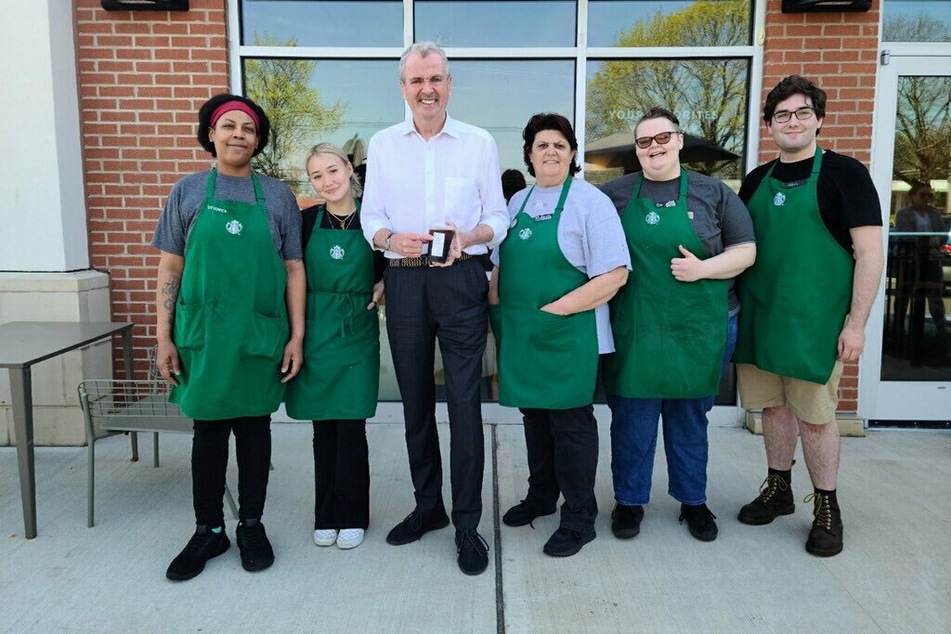 Starbucks workers at the Hamilton location pose with New Jersey Gov. Phil Murphy ahead of their union vote.