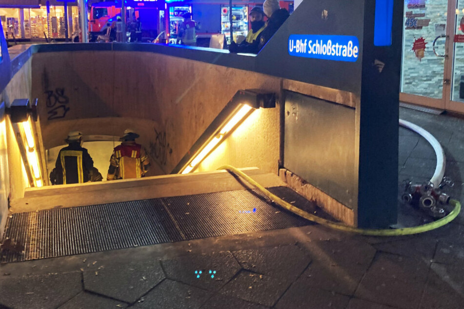 Feuerwehrleute gehen an der Schloßstraße in Steglitz in einen Eingang der U-Bahn.