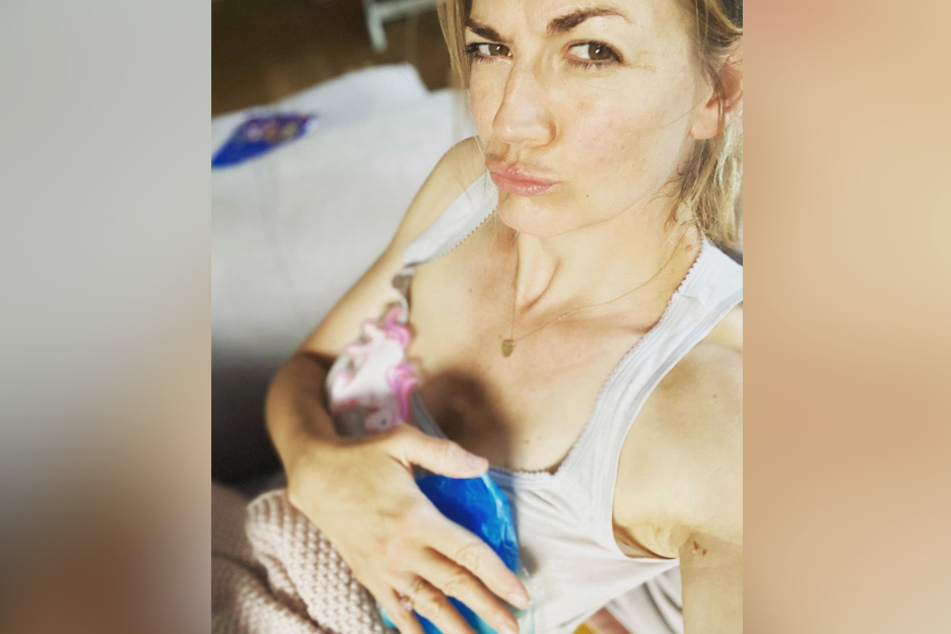 Gegen die Schmerzen kühlt Nina Bott ihre Brüste.