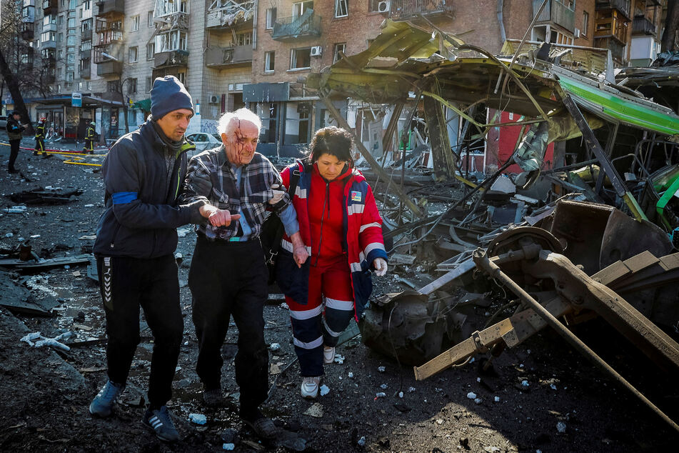 Emergency responders help an injured resident after a Russian missile strike on Kyiv.