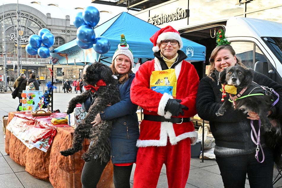 Anja Bahr (38, v.l.n.r.) mit Hund Kuba (3), Andreas Bahr (54) und Stefanie Tabor (40) mit Hund Vilma (12) verteilen kostenloses Hundefutter.