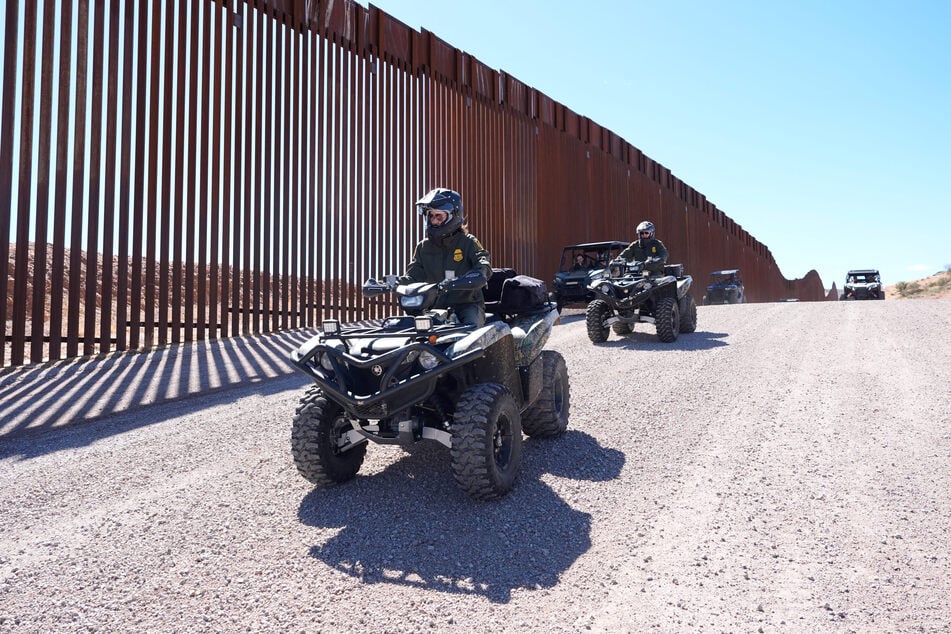 Secretary of Homeland Security Kristi Noem (L) rides a four-wheeler during a tour along the Nogales border wall at the Mariposa Port of Entry in Nogales, Arizona, March 15, 2025.