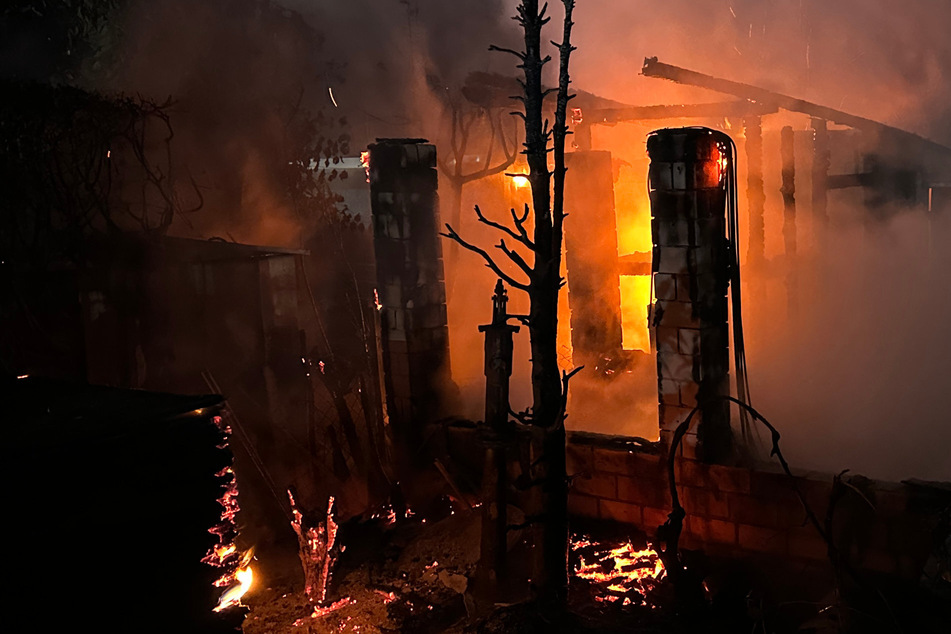 Feuer im Kleingartenverein: Einsatzkräfte kämpfen mit Atemschutz gegen Flammen