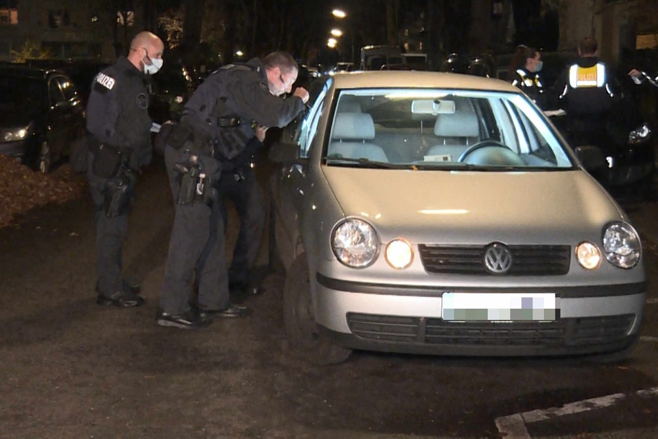 Polizeibeamte leuchten in das Fahrzeug des Opfers.