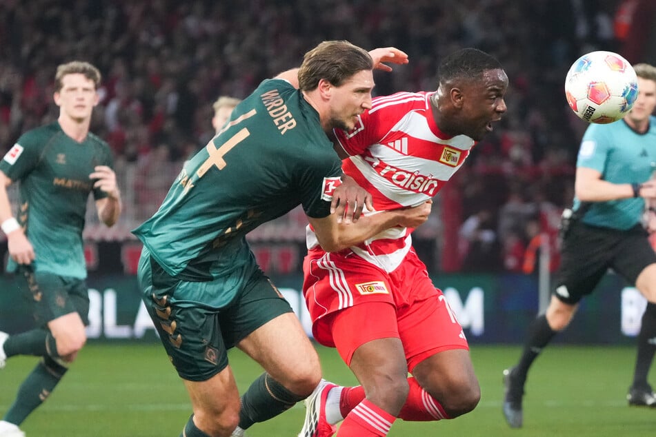 Ex-Herthaner Niklas Stark zieht zu lange am Trikot von Unions Ilyas Ansah (r.)