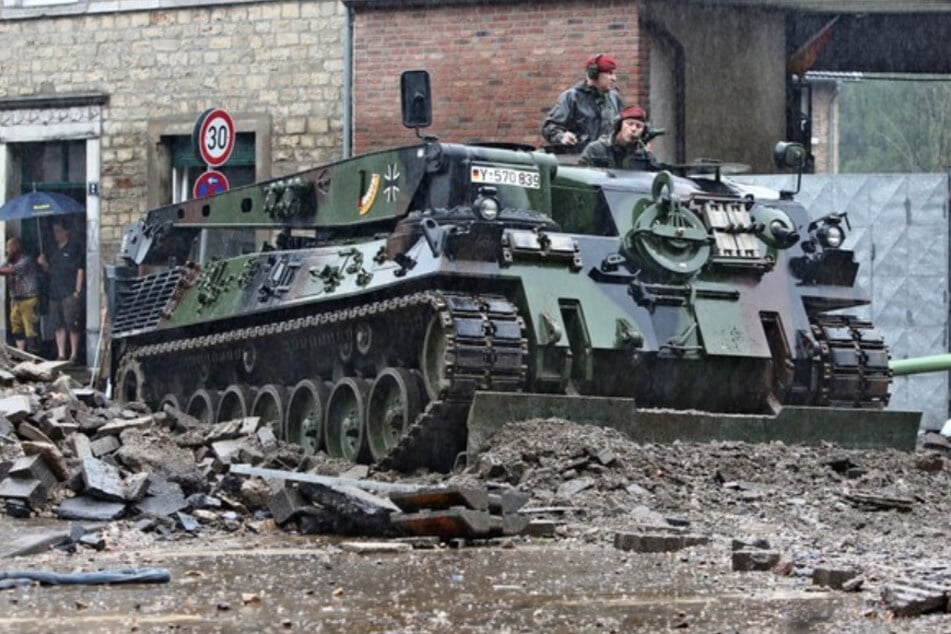 Ein Einsatzfahrzeug der Bundeswehr räumt in Aachen Geröll von der Straße.