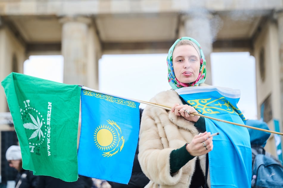 Eine Demonstrantin steht mit einem Joint vor dem Brandenburger Tor und demonstriert für eine schnelle Legalisierung von Cannabis.