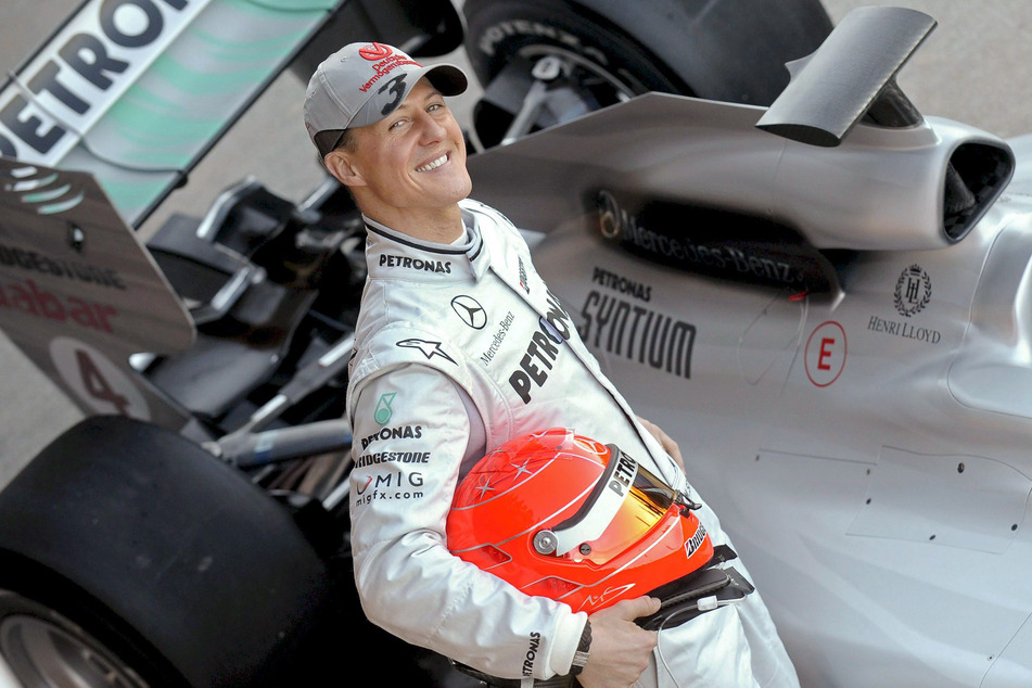 Michael Schumacher (54) posiert im Jahr 2010 neben seinem Mercedes GP Rennwagen auf der Rennstrecke in Valencia.