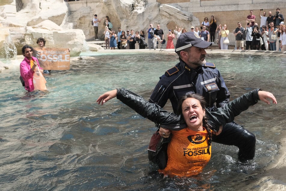 Klimaaktivisten der "Letzten Generation" werden von Polizisten aus dem Wasser getragen.