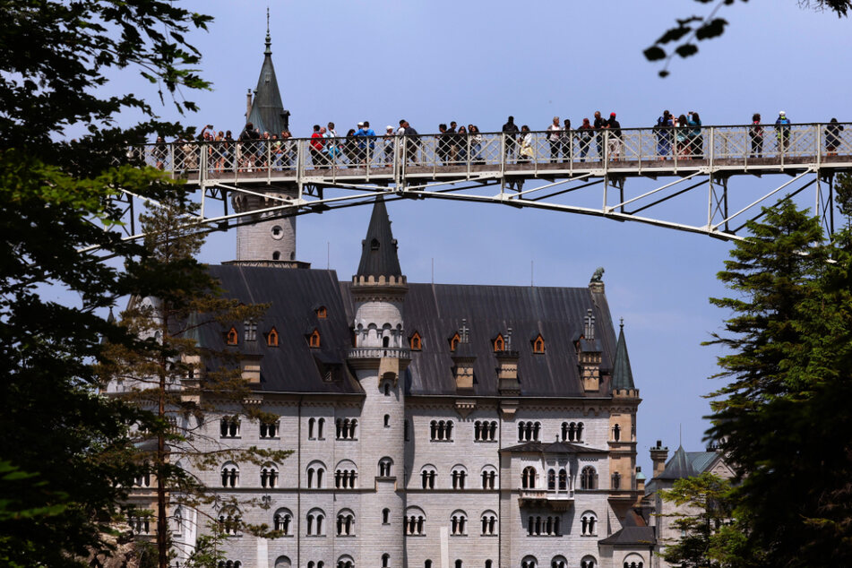 Touristen stehen auf der Marienbrücke vor dem Schloss Neuschwanstein. Ganz in der Nähe fand die schreckliche Tat statt.
