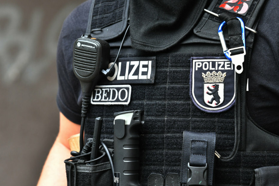 Ein Polizeibeamter steht bei einem Einsatz vor einem Gebäude in Berlin-Neukölln. (Archivbild)