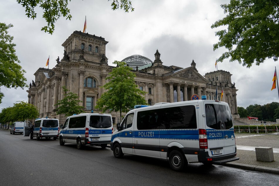Vor dem Reichstagsgebäude stehen Polizeiautos. Die Polizei hat das Regierungsviertel wegen angekündigten Querdenker-Demonstrationen gegen die Corona-Politik weiträumig abgesperrt.