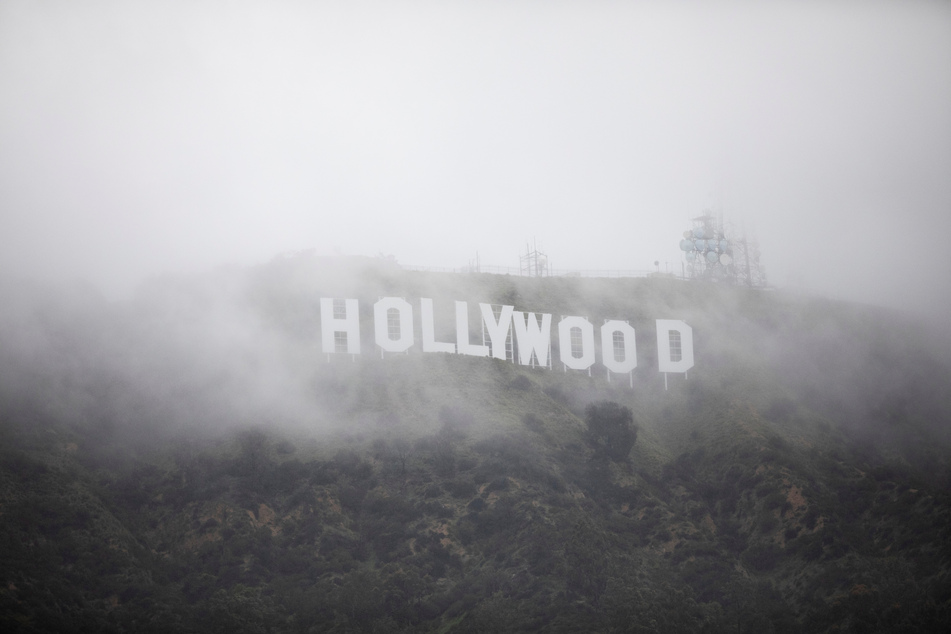 The Hollywood sign is seen through a mix of fog and dust snow during a rare cold winter storm in the Los Angeles area.