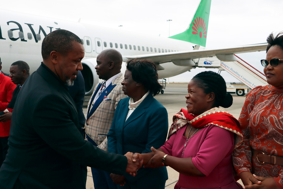 Malawis Vizepräsident Saulos Chilima (l.) begrüßt Regierungsvertreter nach seiner Rückkehr aus Südkorea.