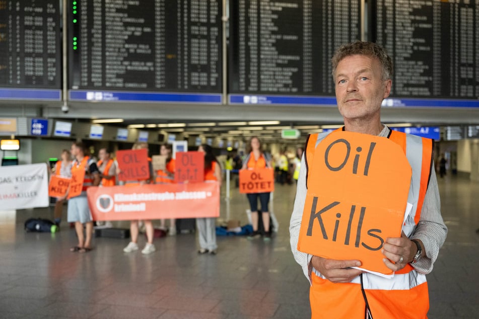 Mit Plakaten, unter anderem mit der Aufschrift "Öl tötet", fanden sich die Aktivisten der "Letzten Generation" am Frankfurter Airport ein.