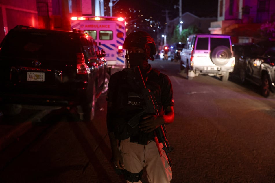 A police officer stands guard near a local hospital where Haiti's interim Prime Minister Garry Conille is receiving treatment.