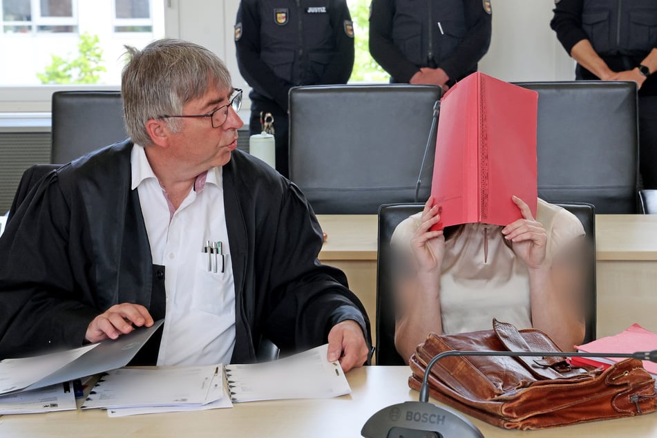 Andreas Ohm (l-r), Anwalt, und die Angeklagte am vierten Verhandlungstag im Saal des Landgerichts.