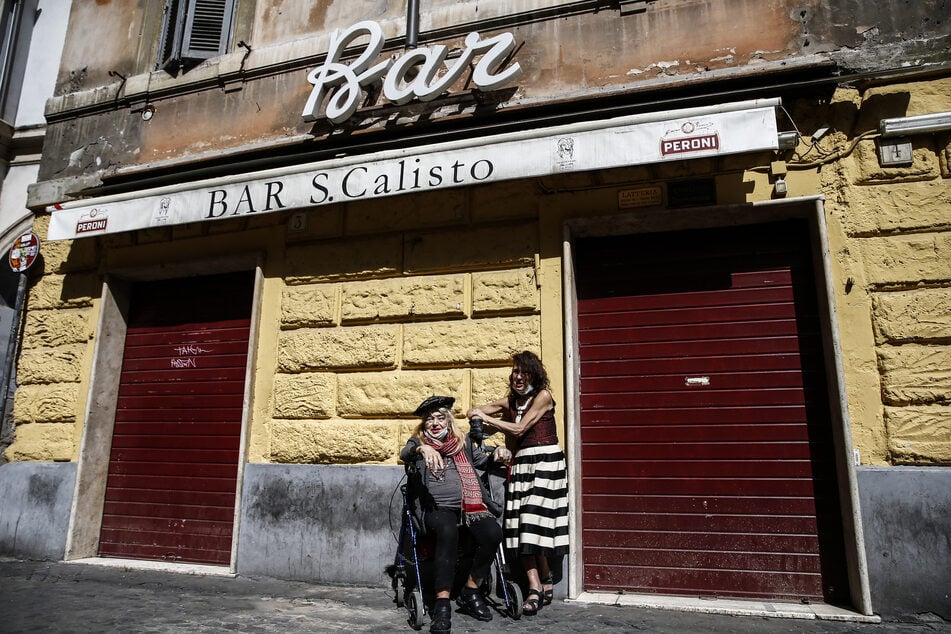 Frauen stehen vor einer geschlossenen Bar im Viertel Trastevere.