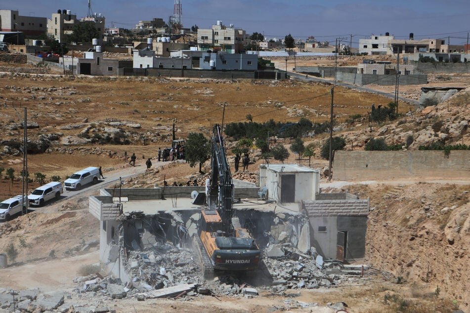 Ein israelischer Bagger reißt ein palästinensisches Haus in der Stadt Yatta, südlich der Westjordanland-Stadt Hebron, ab.