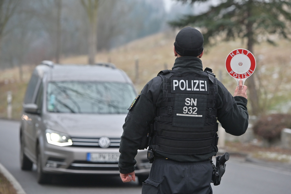 Vor dem Ortseingang an der Bahnhofstraße unterhalb von Seiffen zieht ein Polizist ein ortsfremdes Fahrzeug aus dem Verkehr.