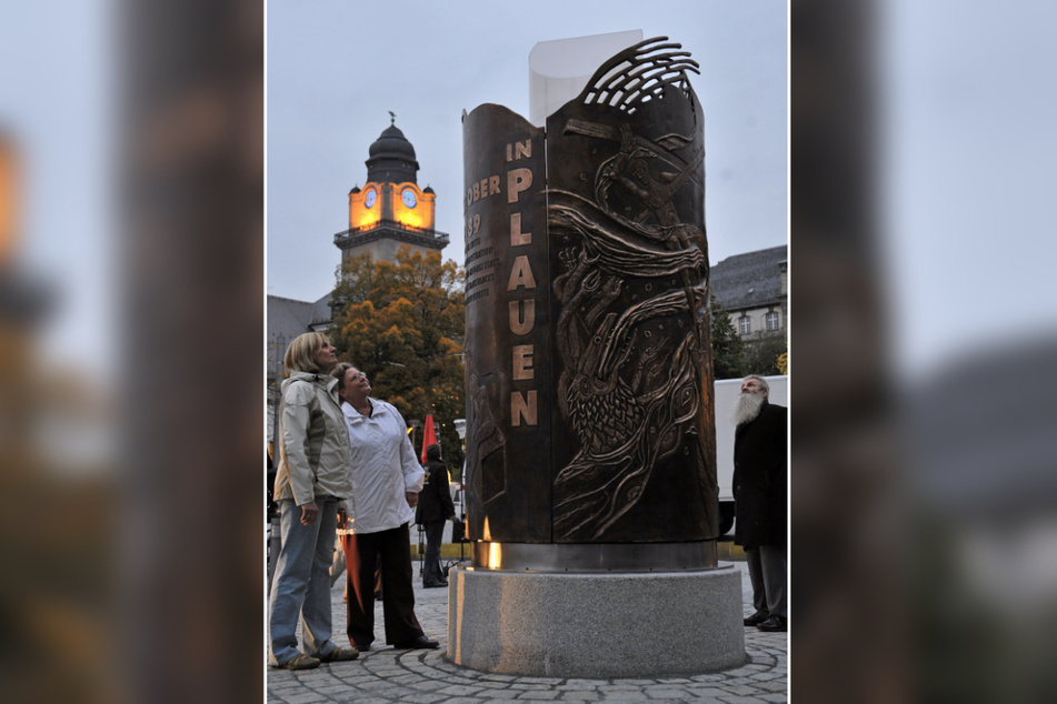 Wie eine Kerze, die nie verglüht: das Wende-Denkmal vor dem Rathausturm.