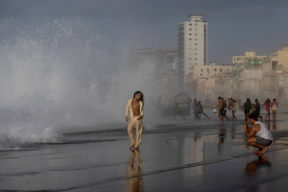 Eine Frau lässt sich fotografieren, während Hurrikan "Ian" über Kuba tobt.
