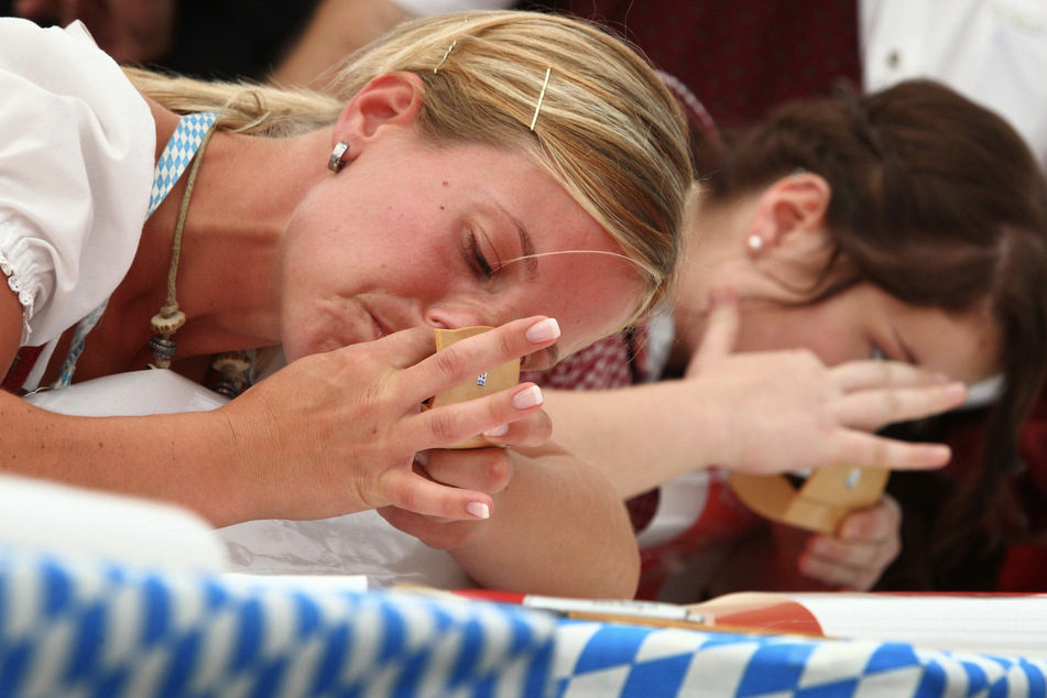 Zwei Teilnehmerinnen versuchen innerhalb von einer Minute fünf Gramm Schnupftabak in ihre Nase zu befördern.