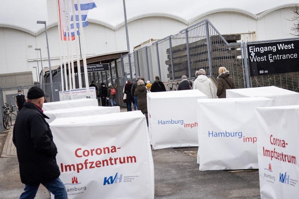 Menschen stehen vor dem Corona-Impfzentrum an den Hamburger Messehallen.
