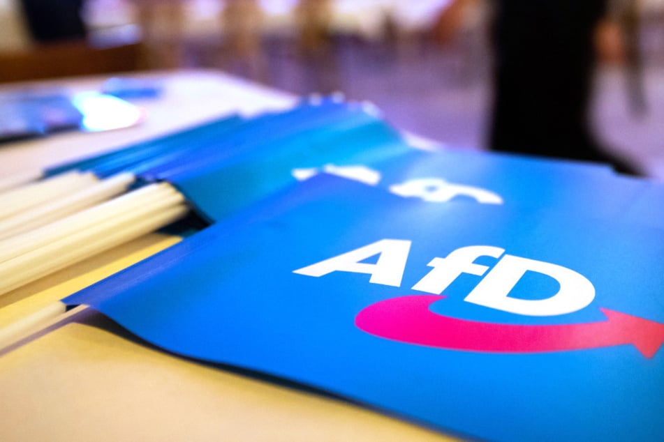 Fähnchen mit dem Logo der AfD liegen auf einem Tisch. (Symbolbild)