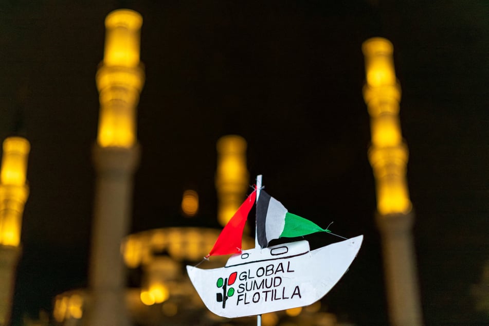 A Palestine demonstrator displays a representation of a boat during a protest after Israel intercepted some of the vessels of the Global Sumud Flotilla near the Israeli Consulate in Istanbul, Turkey, on October 2, 2025.