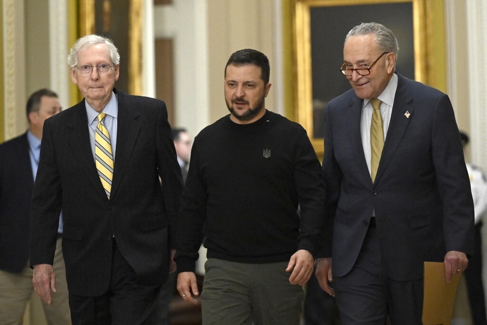 Ukrainian President Volodymyr Zelensky (c.) walks between Senate Majority Leader Chuck Schumer (r.) and Minority Leader Mitch McConnell during a visit to Washington DC on December 12, 2023.