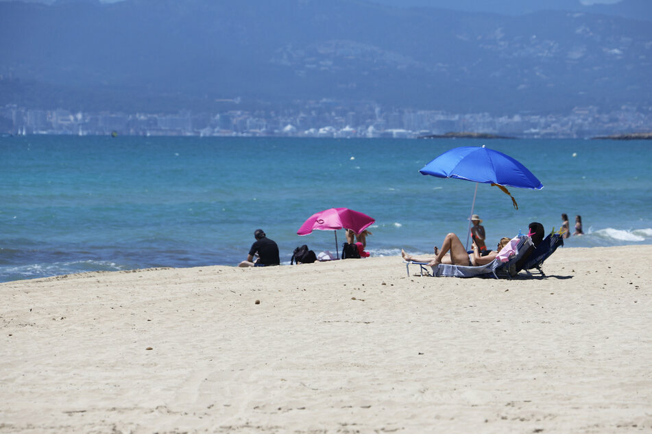 Badegäste liegen am Strand Playa de Palma.