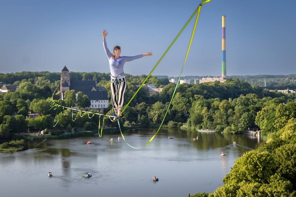 Eines der "leisen" Highlights beim Kosmos Festival 2025 über dem Schlossteich: Slacklinerin Miri (29) aus Schliersee läuft in luftiger Höhe zwischen Hochhaus und Schloßkirche.