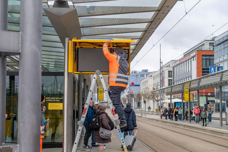 Hier sind Techniker mit dem Austausch der Anzeigen am Hauptbahnhof beschäftigt.