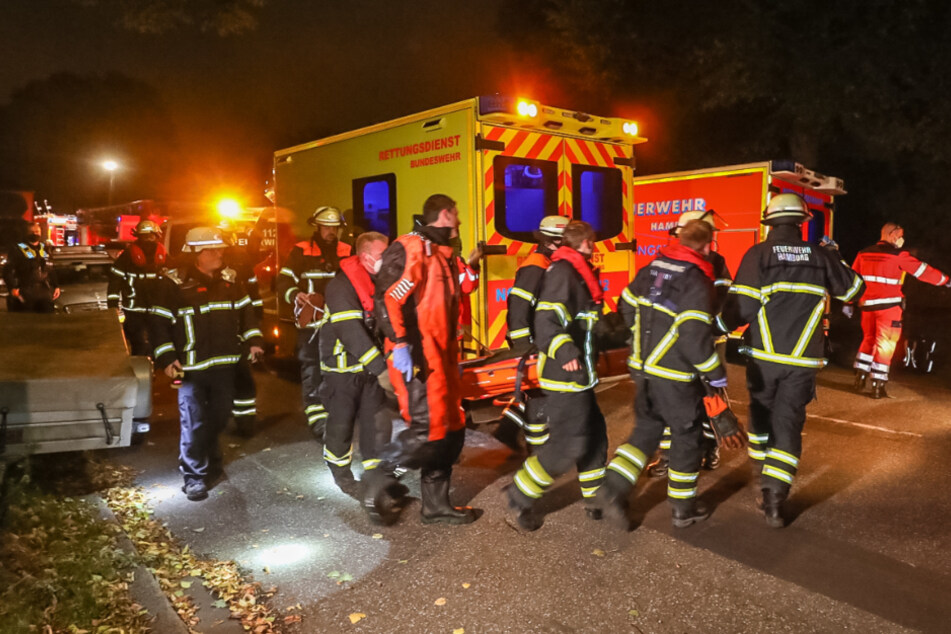 Rettungskräfte der Feuerwehr tragen den Mann zu einem Rettungswagen.