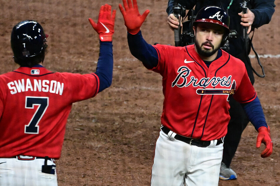 Travis d'Arnaud (r) is congratulated by Dansby Swanson (l) after hitting a solo home run in the 8th inning of Atlanta's game three win.