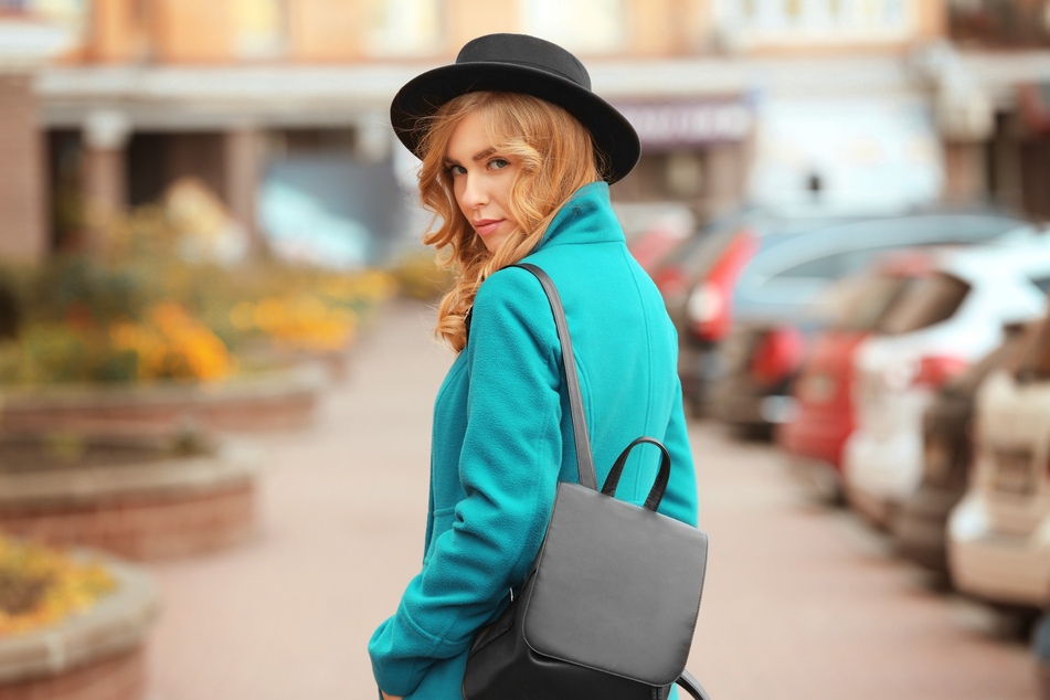 City-Rucksack, Hut und ein türkisfarbener Stoff können Dich jünger aussehen lassen. (Symbolbild)